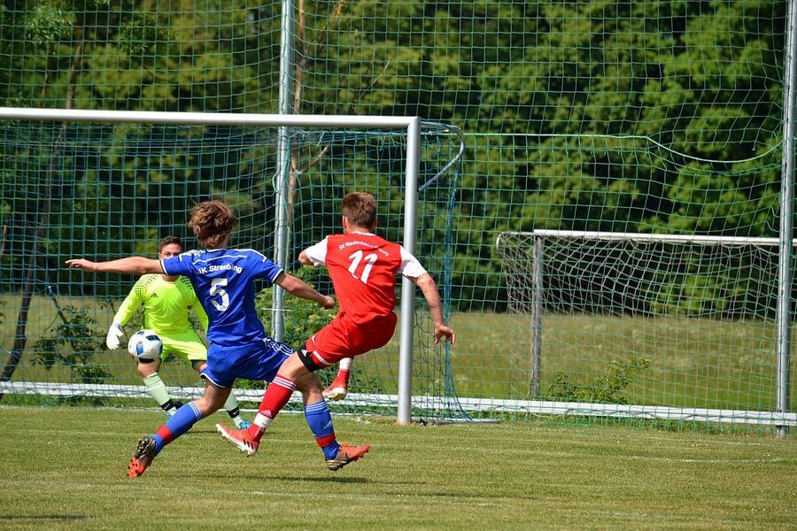 Spieler von hinten, die auf das Tor schießen