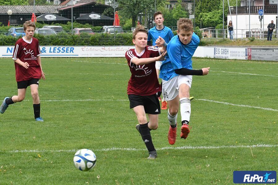 Zwei aneinanderstoßende Fußballspieler, die dem Ball hinterherlaufen