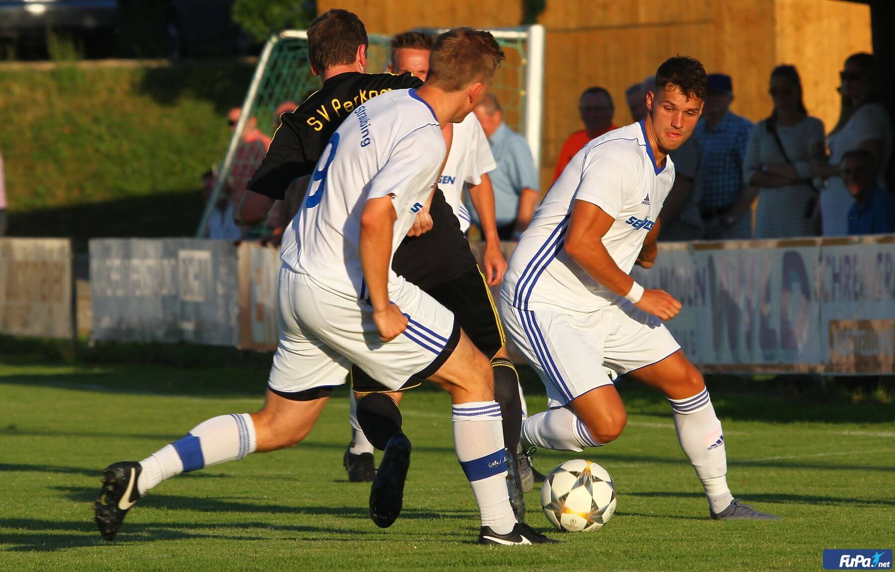 mehrere Spieler die um den Ball spielen