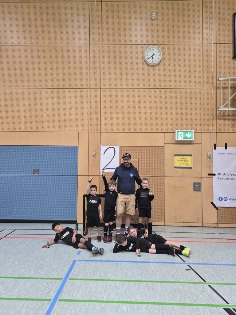 G-Jugend Team der DJK Straubing mit Trainer vor der Platz-2-Tafel beim Hallenturnier