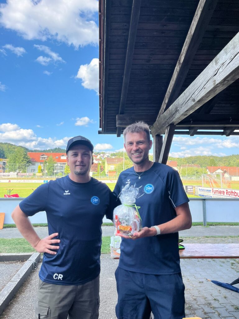 Trainer Christian R. der DJK SB Straubing überreicht Präsent an Gasttrainer am Sportgelände in Straubing