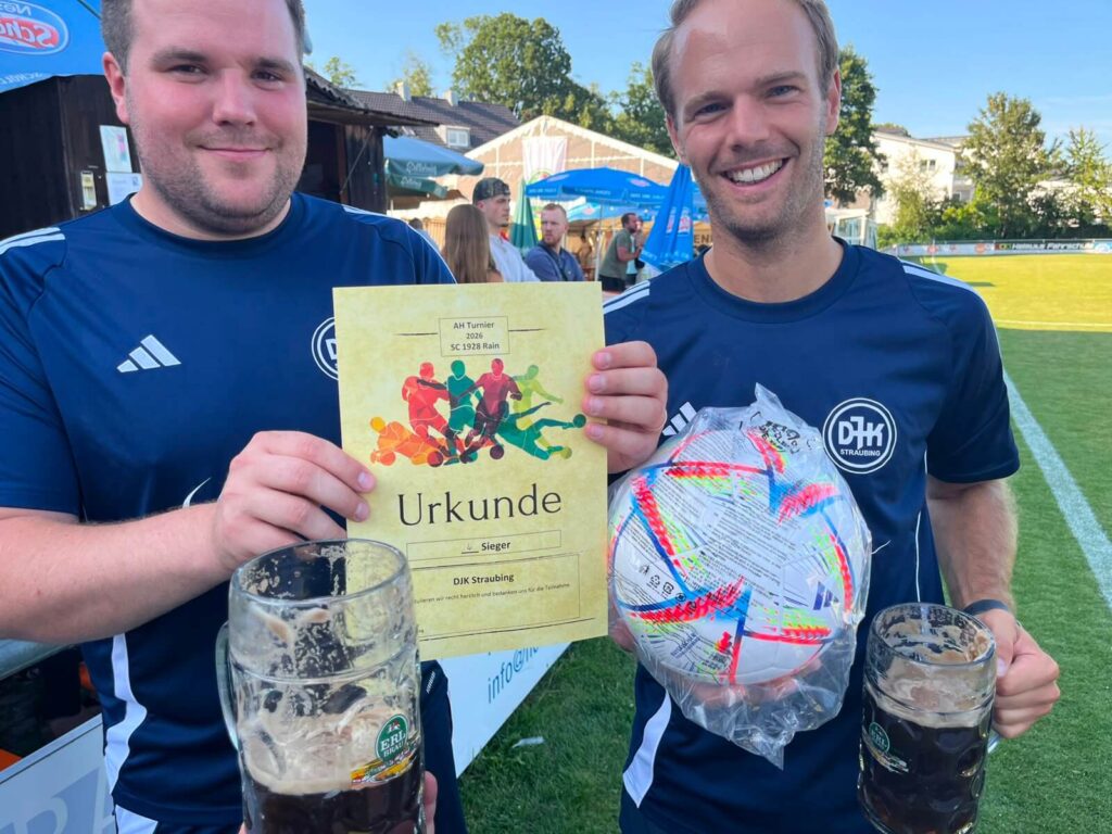 Zwei Spieler der AH DJK Straubing präsentieren Urkunde und Siegerball nach dem AH-Kleinfeldturnier des SC 1928 Rain 2026.