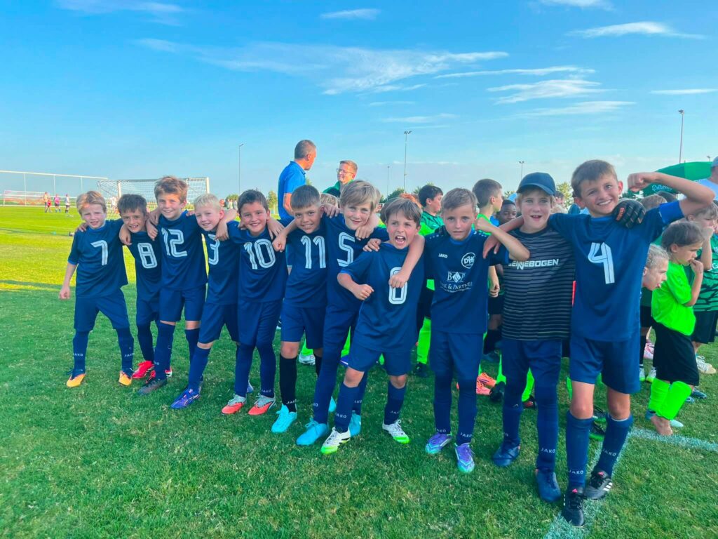 Spieler der F1-Jugend der DJK SB Straubing feiern ausgelassen Arm in Arm den Turniersieg beim Kiwanis Cup 2026 in Alburg.