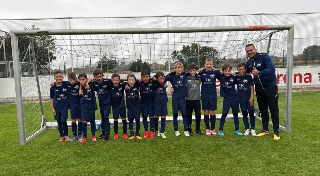 DJK Straubing E1 Jugendmannschaft nach dem 2. Platz beim E-Jugend-Turnier in Pankofen 2026 in dunkelblauen JAKO-Trikots vor dem Tor