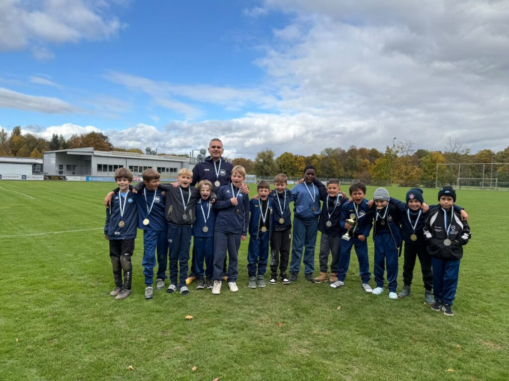 Jubelnde Spieler der DJK SB Straubing E1 mit Medaillen, Pokal und Trainer Sinisa Stojanovic nach der Herbstrunde 2026